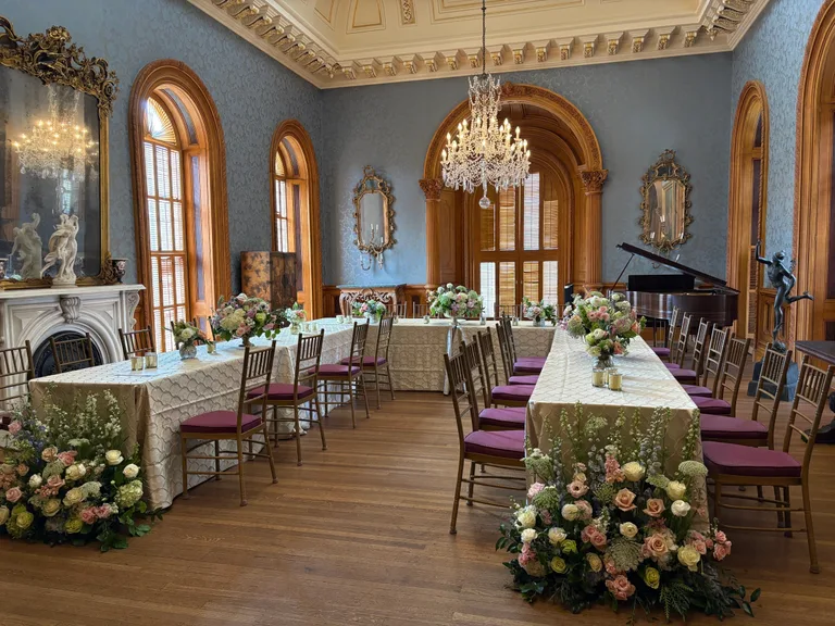 A Hay House room set with long tables and florals