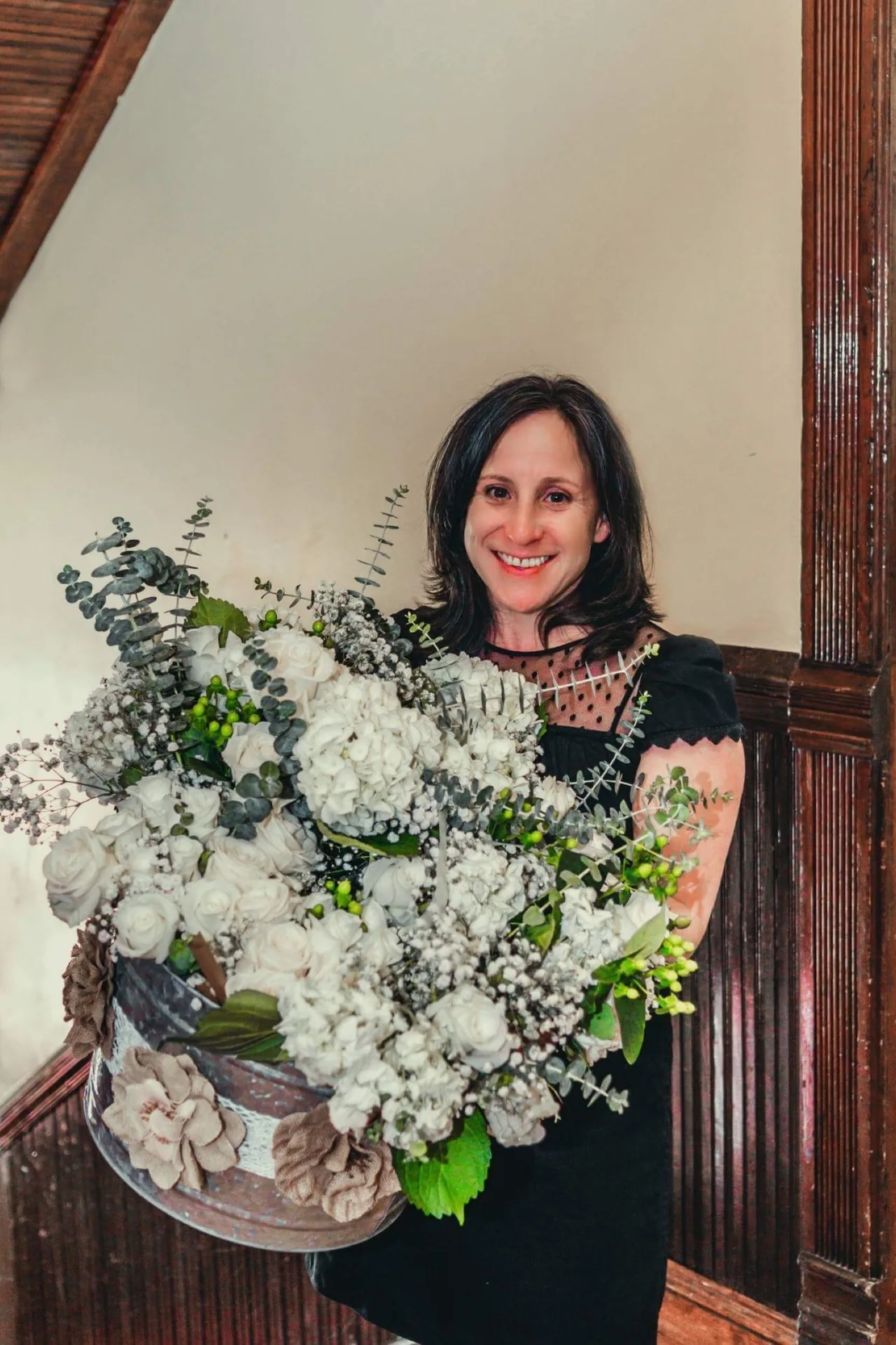 Corinne holding a white floral arrangement