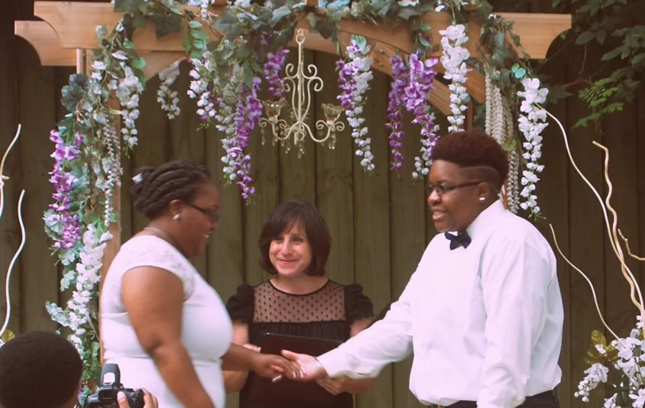 A couple with their officiant during their ceremony