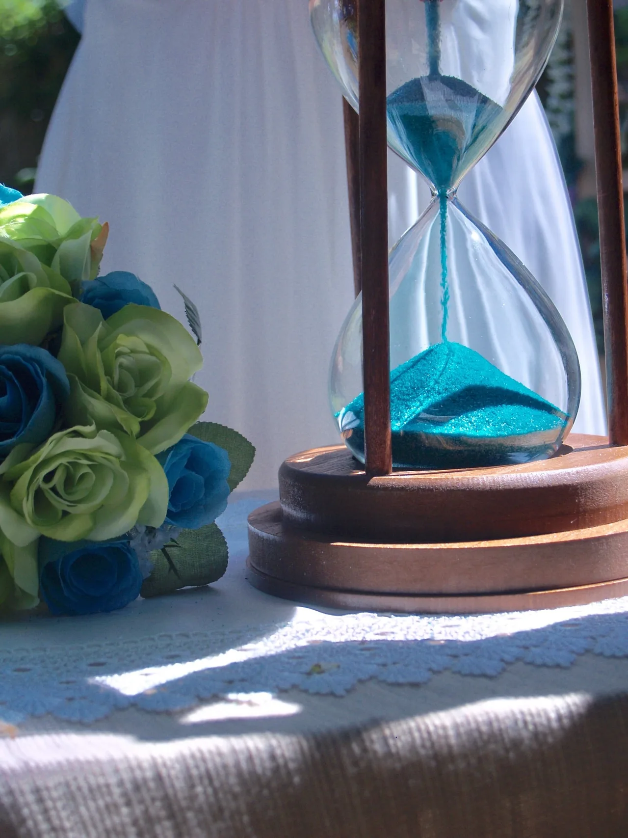 A sand-ceremony detail beside a bouquet