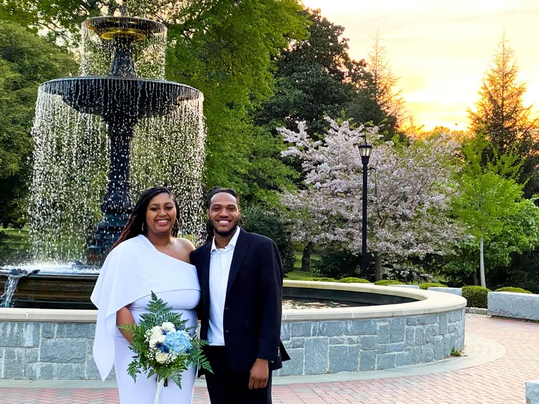 A couple beside a fountain and flowering trees